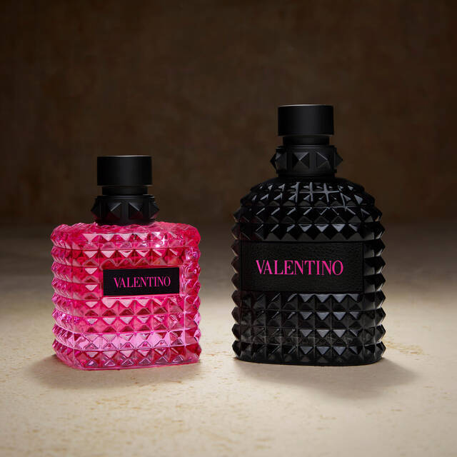 Due flaconi di profumo Valentino, uno rosa e uno nero, con un design elegante a piramidi e etichetta in evidenza.
