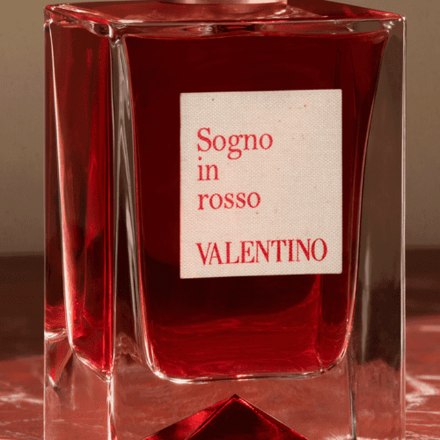 Flacone di profumo in vetro trasparente con etichetta bianca che recita "Sogno in rosso" e "VALENTINO".